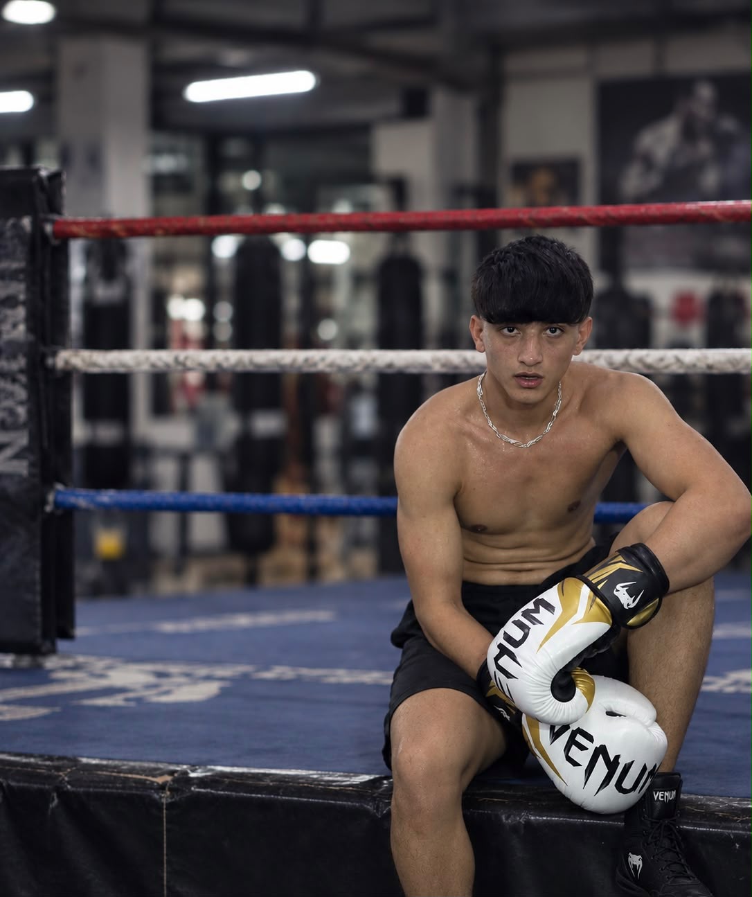 The same Fit2Fight member after 10 weeks of coaching, ringside in boxing gloves